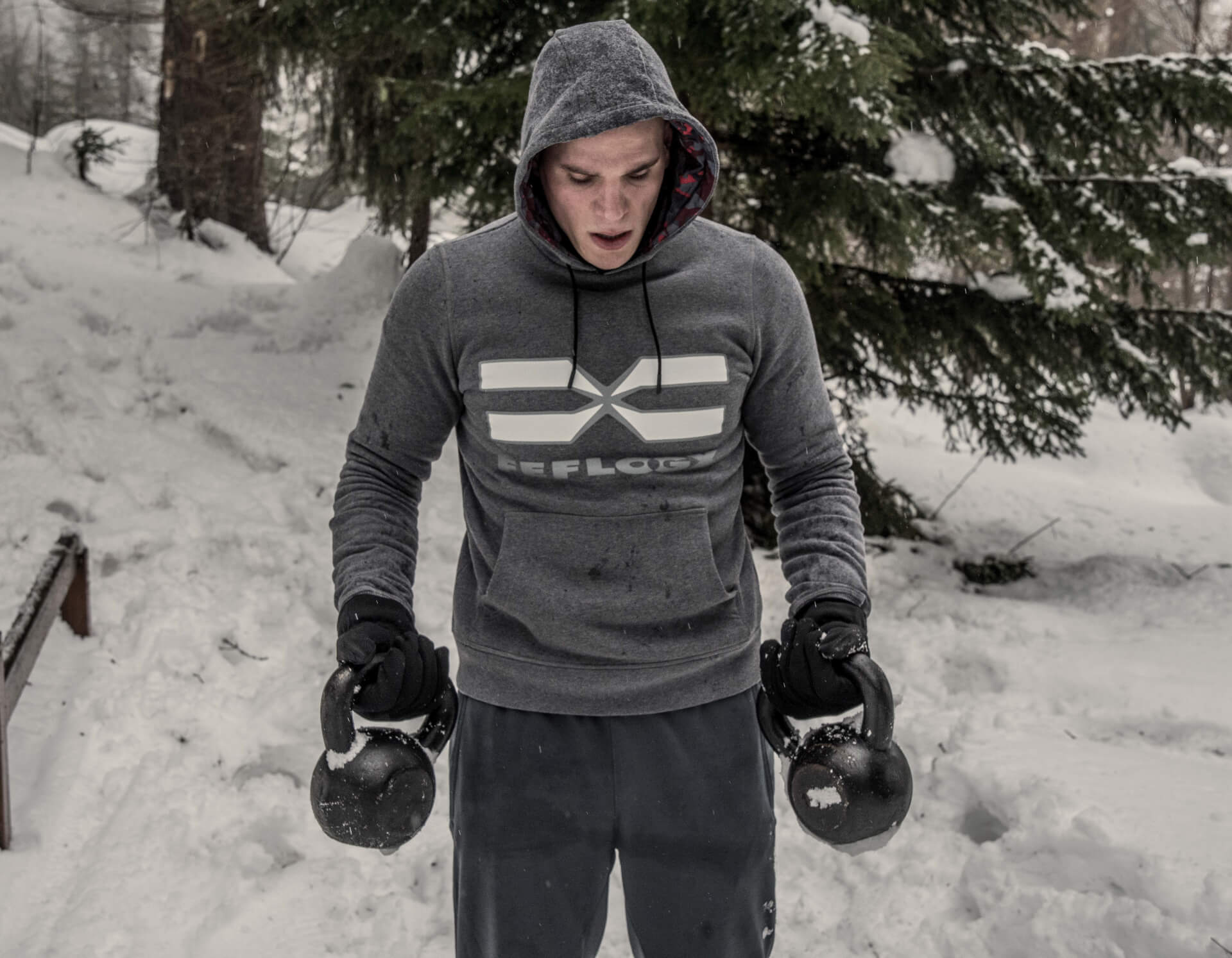 FEFLOGX Sportswear After-Train-Hoodie Winter-Workout mit Kugelhanteln im Schnee.