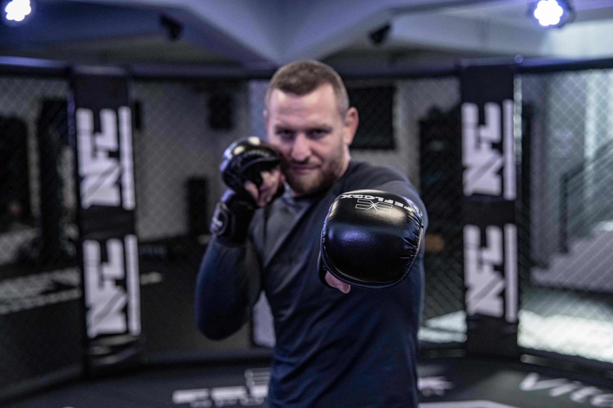 Max Schwindt, Ringer Profi, mit FEFLOGX Sportswear Rashguard lang und MMA Sparringshandschuhen im NFT Cage der NFC in Krefeld.