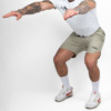 FFX Kurze Jogginghose Shorts Endurance Force von FEFLOGX Sportswear, mit Reißverschlusstaschen & Handtuch halter, Kurze Jogginghose in schwarz, beige/sandfarben & schwarz-grau-blau Camouflage, Kurze Sporthose Herren, Laufshorts Herren, Sporthose kurz, Laufhose, kurze Trainingshose, seitliche Ansicht links vorne Action Bild, der beigen/sandfarbenen Sportshorts.
