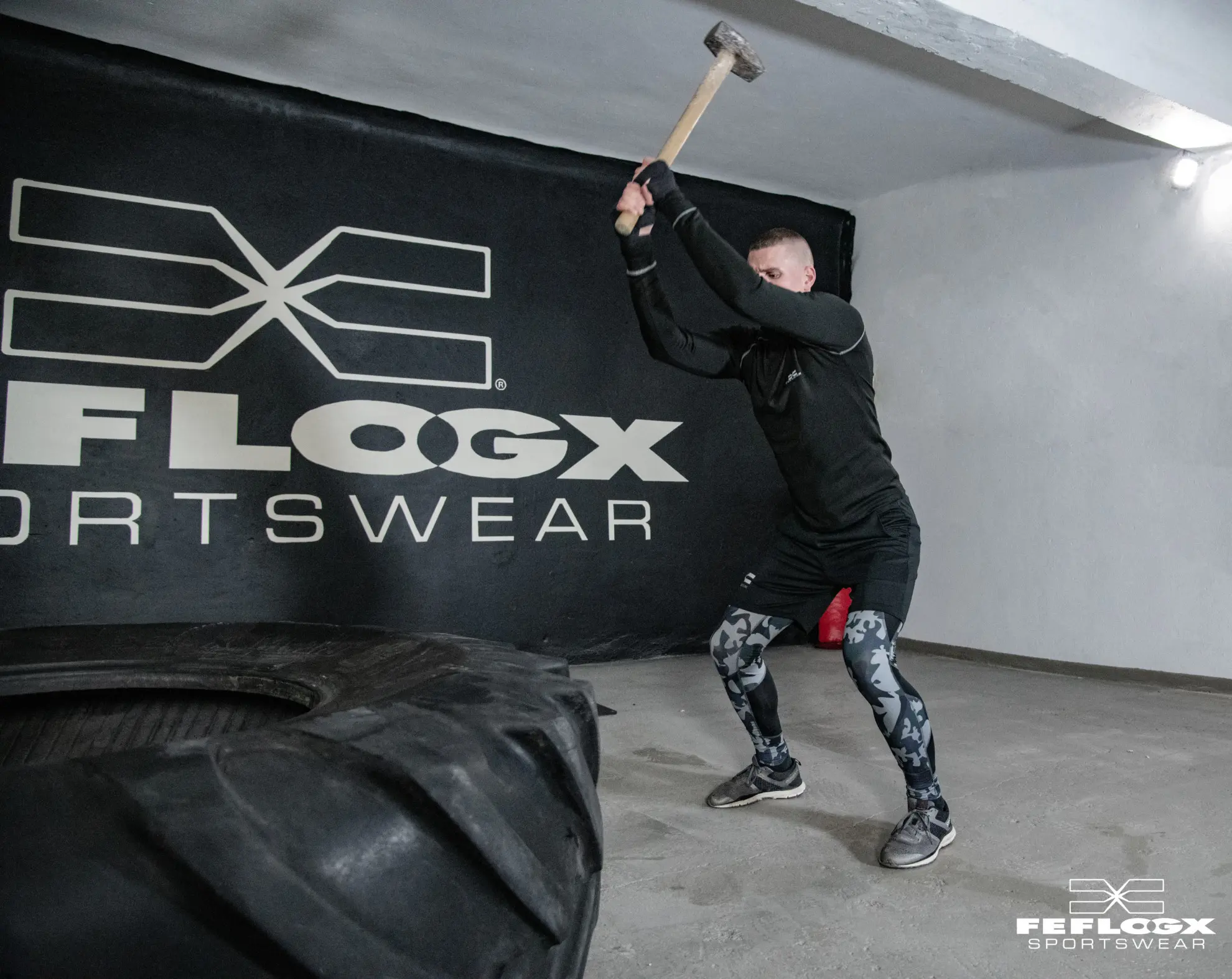 FEFLOGX Sportswear, MMA-Training Shooting in Leggings Camouflage, FFX Shorts & Longsleeve mit Kampfsport Dummy & Reifen mit Hammer schlagen in Industrie Ruine in Frankfurt am Main (2).