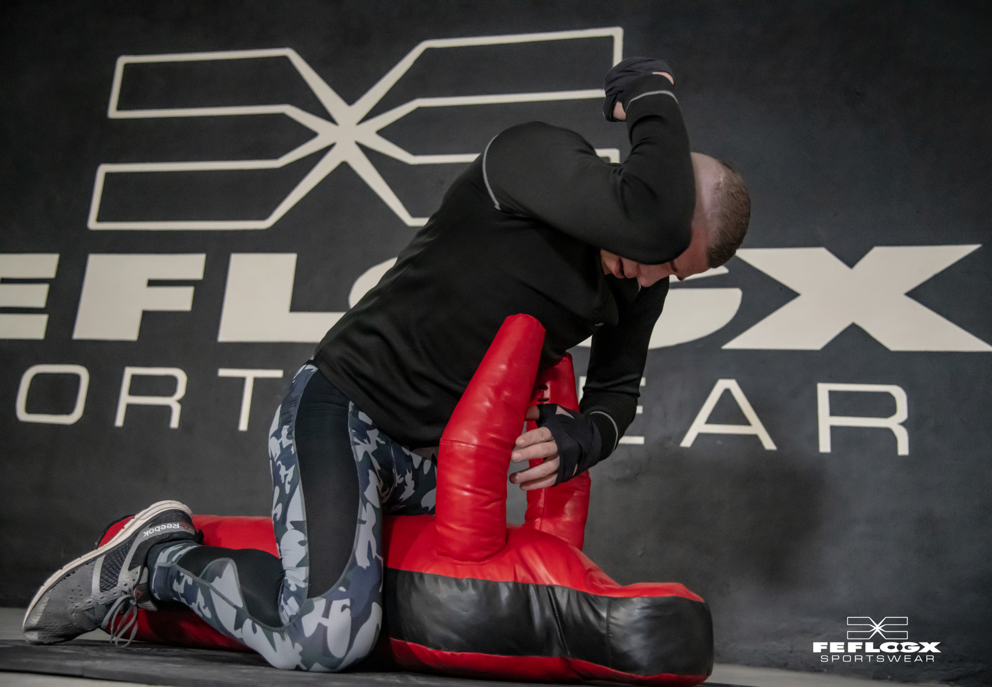 FEFLOGX Sportswear, MMA-Training Shooting in Leggings Camouflage, FFX Shorts & Longsleeve mit Kampfsport Dummy & Reifen mit Hammer schlagen in Industrie Ruine in Frankfurt am Main.