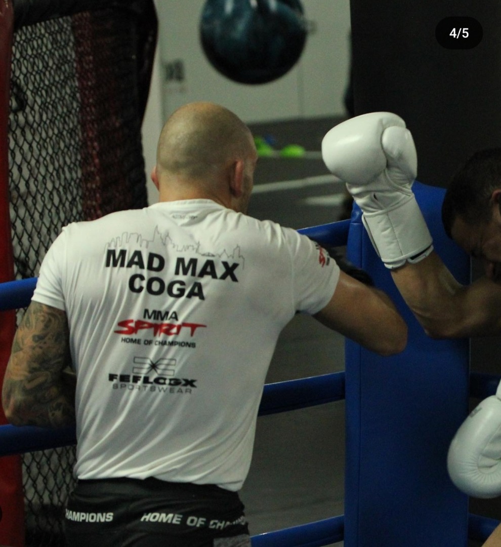 FEFLOGX Sportswear Sponsoring vom MMA Spirit & MMA Fighter, Mad Max Coga, PFL MMA & Oktagon MMA Fighter, sowie Pik Dame Besitzer in Frankfurt am Main. Boxtraining in dem Mad Max Fanshirt von FEFLOGX des MMA Kämpfer im Cage.