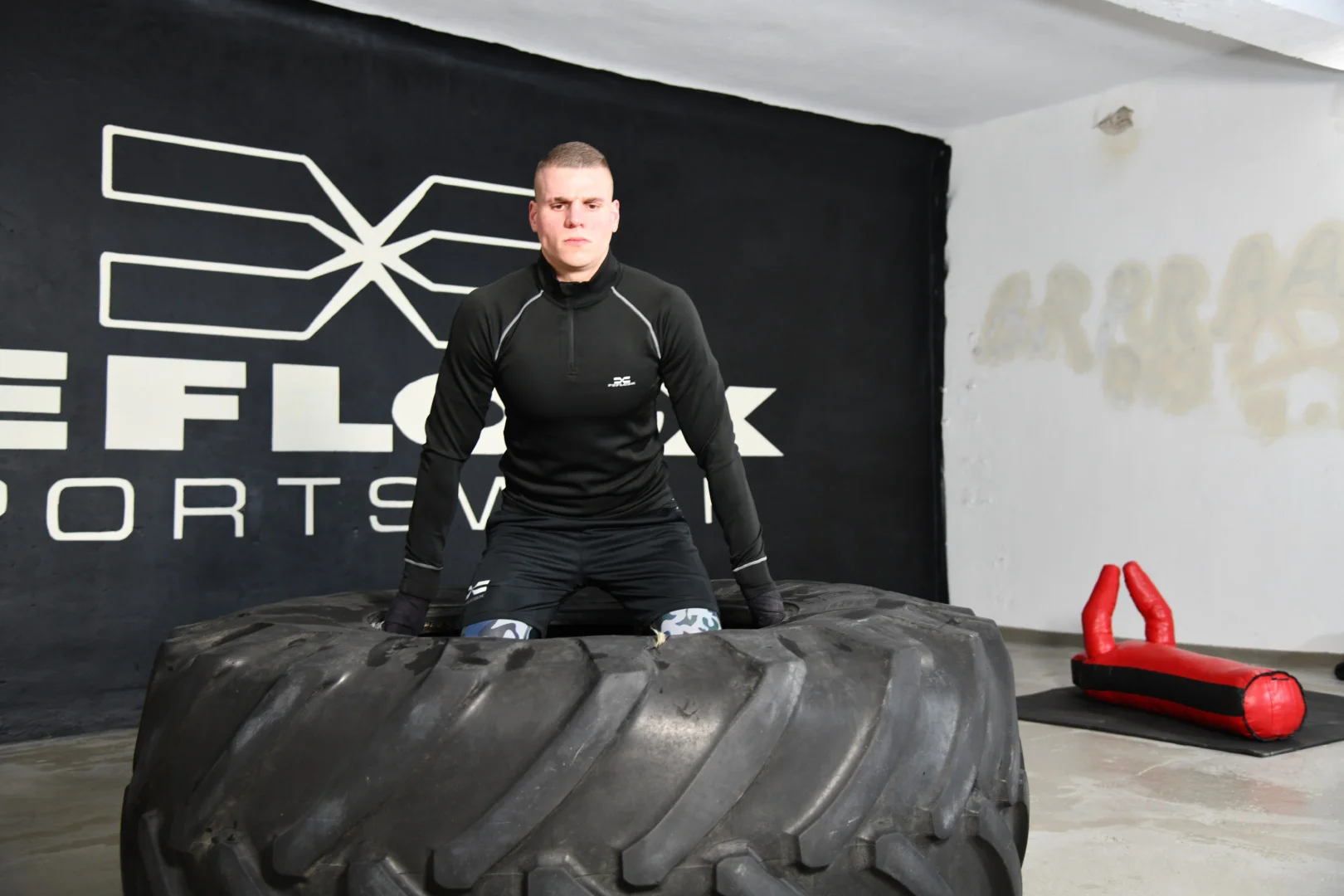 FEFLOGX, MMA-Training & Urban Functional Fitness Shooting in FFX Sport Leggings Camouflage, FFX Sport Shorts, FFX Boxbandagen & Sport Sweater, Fitness Longsleeve mit Kampfsport Dummy & Sport Reifen mit Hammer schlagen, Reifn Heben & Umkippen, Training auf Traktorreifen in Industrie Ruine in Frankfurt am Main, mit FEFLOGX Logo-Graffiti an der Wand (32).