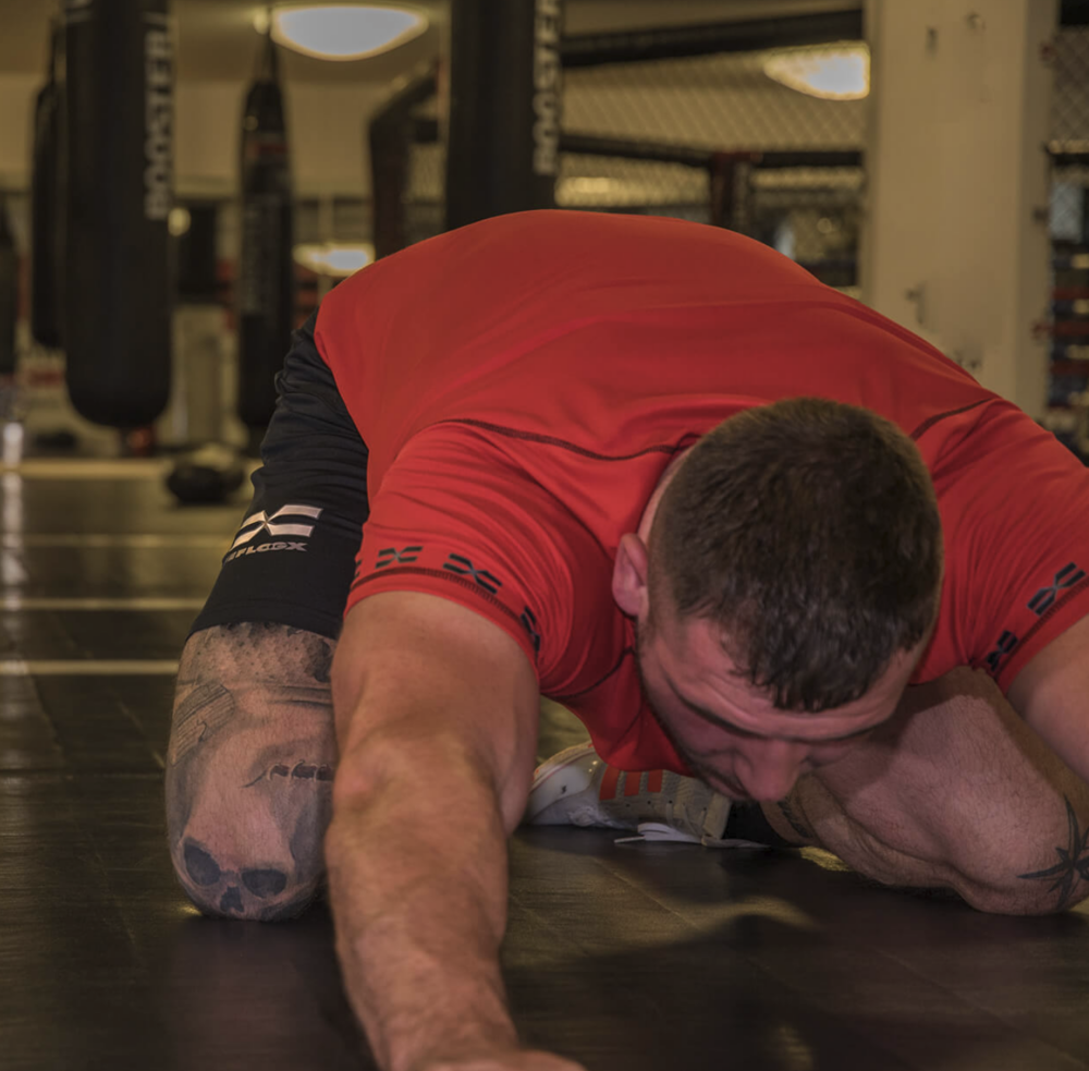 FEFLOGX beim MMA Training mit Wolf Frankfurt, Mesh-Shirt in rot und Allrounder Shorts beim Mobility & Stretching.